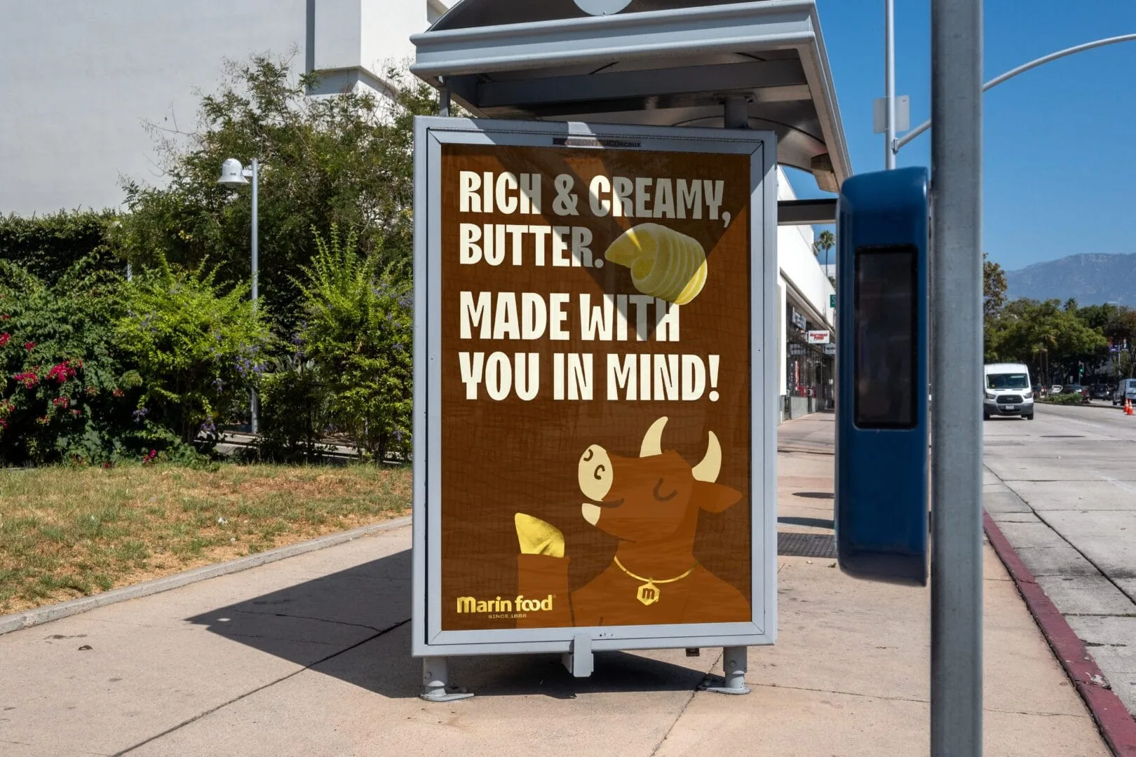 Marin Food butter advertisement with an illustrated cow in a bus shelter mockup